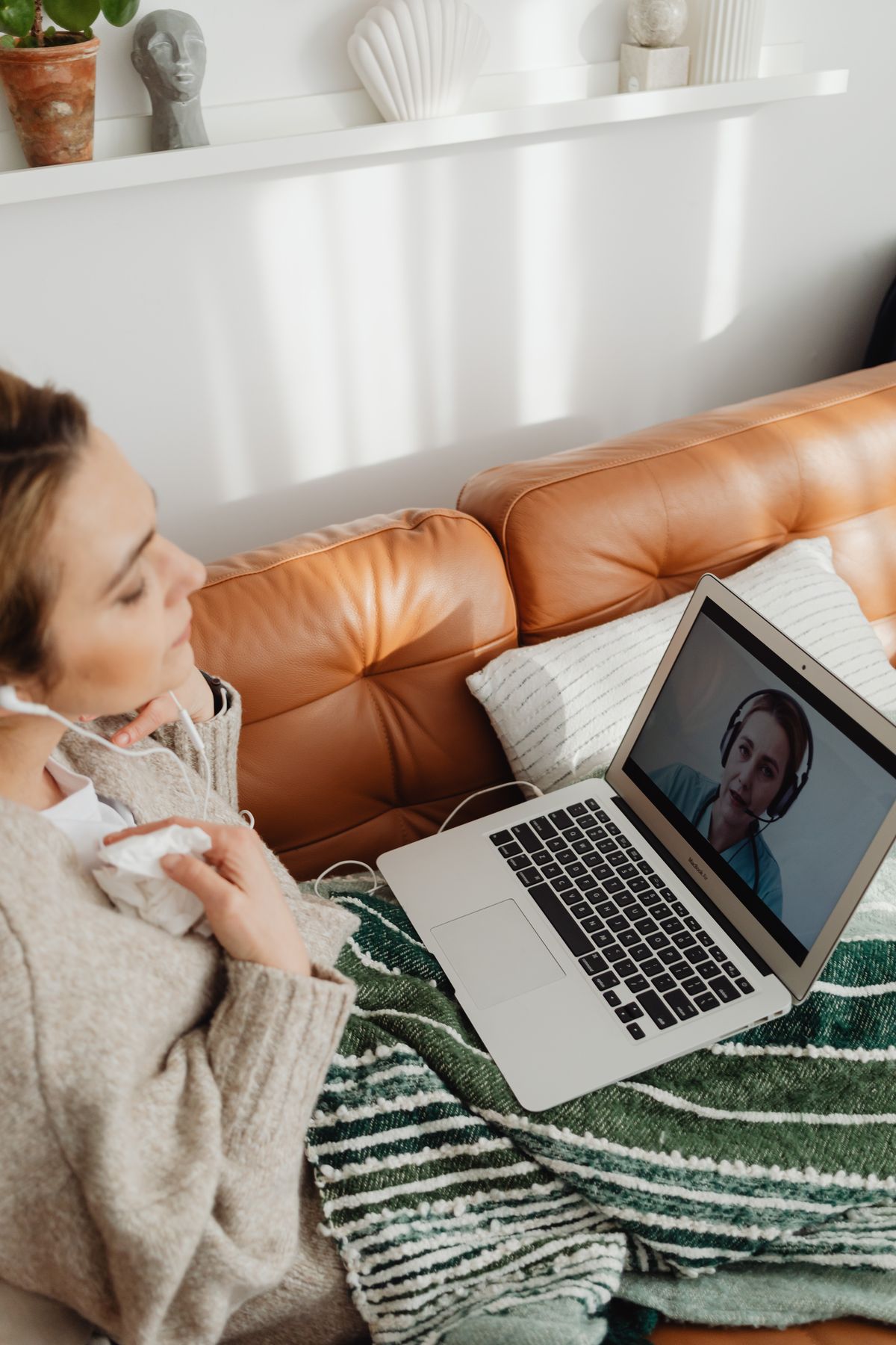 Woman having a video therapy session from her couch